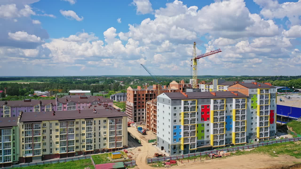 Building of a modern district. Construction site of new complex with high rise buildings. Colorful apartment building in new microdistrict.