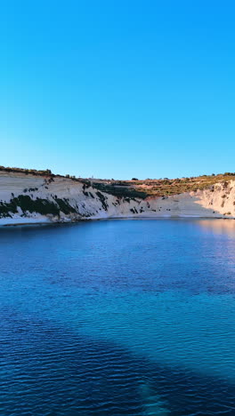 white cliffs at the waterscape of the mediterranean sea. nature of the coast of malta, europe. vertical video.