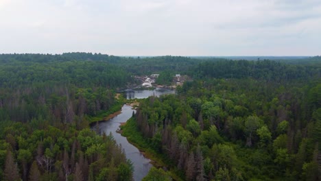 disparo aéreo de avión no tripulado rastreando un río a una cascada de flujo rápido en cascada sobre un afloramiento rocoso en massey, ontario, canadá