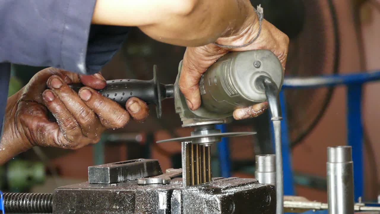 hombre de primer plano moliendo una pieza de metal