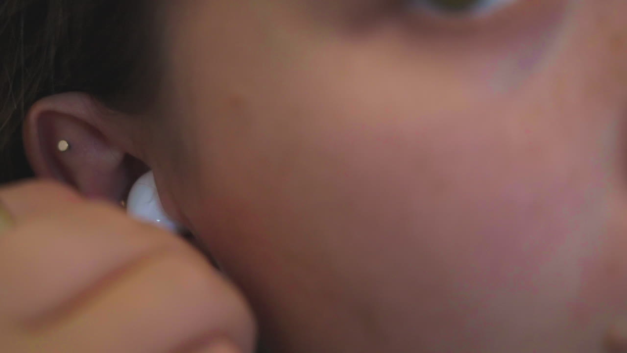 disparo en cámara lenta de una mujer moviendo su cabello y poniendo un auricular inalámbrico