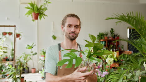 hombre en una tienda de plantas con una planta