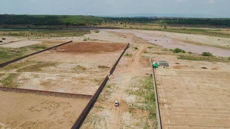 aerial drone shot of agricultural land ready for harvesting and the green tropical forest on the distance in punjab