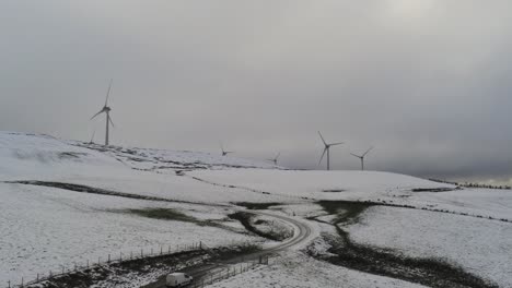 campo de montaña de invierno turbinas de viento en las tierras altas rurales vista aérea frío valle nevado ladera tirar hacia atrás tiro ascendente