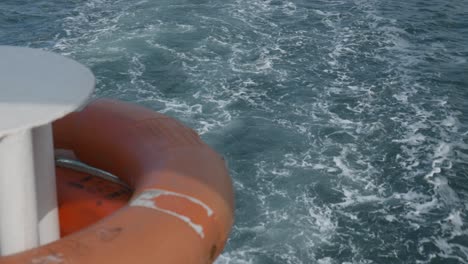 Boot-Erzeugt-Turbulenten-Kielwasser-Am-Heck-Des-Schiffes-Mit-Orangefarbener-Rettungsboje