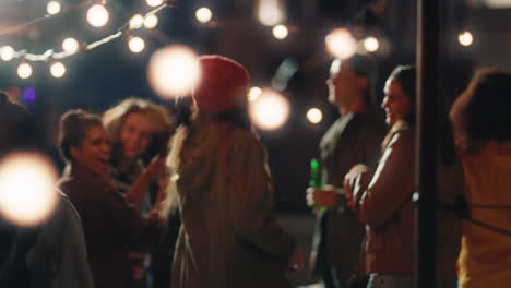 happy friends dancing celebrating on rooftop at night enjoying party weekend having fun socializing hanging out drinking alcohol young group of people celebrate reunion