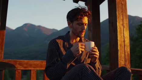 man drinking coffee in the mountains at sunrise