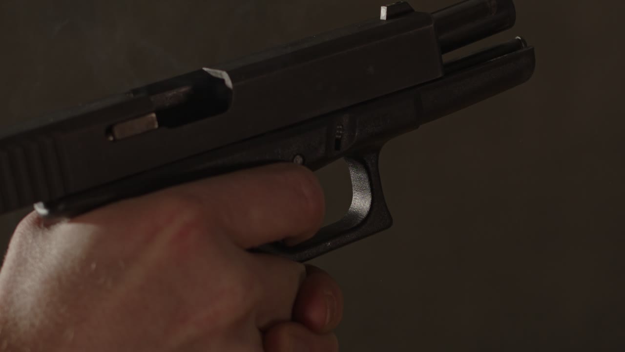 mano disparando una pistola glock 17 en cámara lenta