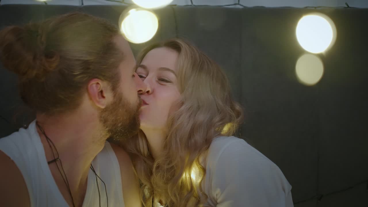 Coppia romantica che si bacia circondata da luci fatate