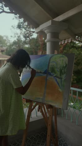 young artist painting landscape on balcony during golden hour, peaceful creative moment