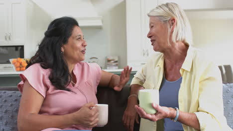 Felices-Y-Diversas-Mujeres-Mayores-Con-Café,-Discutiendo,-Riendo-En-Una-Soleada-Sala-De-Estar,-Cámara-Lenta