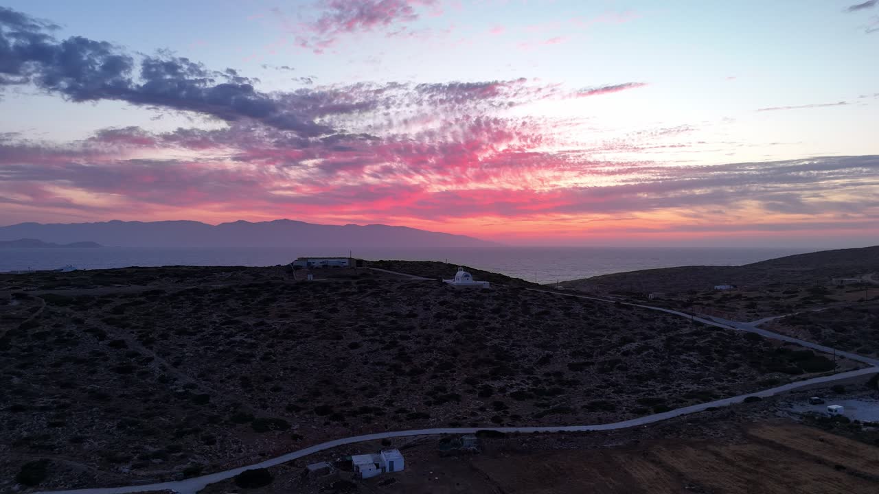 panorámica aérea que establece la muñeca a la iglesia de la santa sabiduría en donousa, grecia, al atardecer