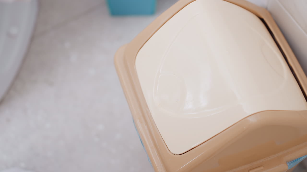 Woman Discarding Used Cotton Pad Into Small Bathroom Bin, Closeup Hand Motion Dropping Pad, Liner And Plastic Bag Visible, Hygiene Routine After Makeup Removal, Simple Waste Disposal, Tidy Apartment