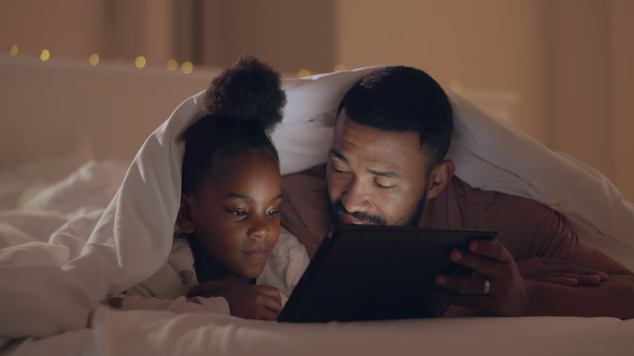 Father, girl and tablet in bed