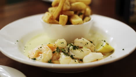 dolly forward of shrimp in cream sauce and french fries dish