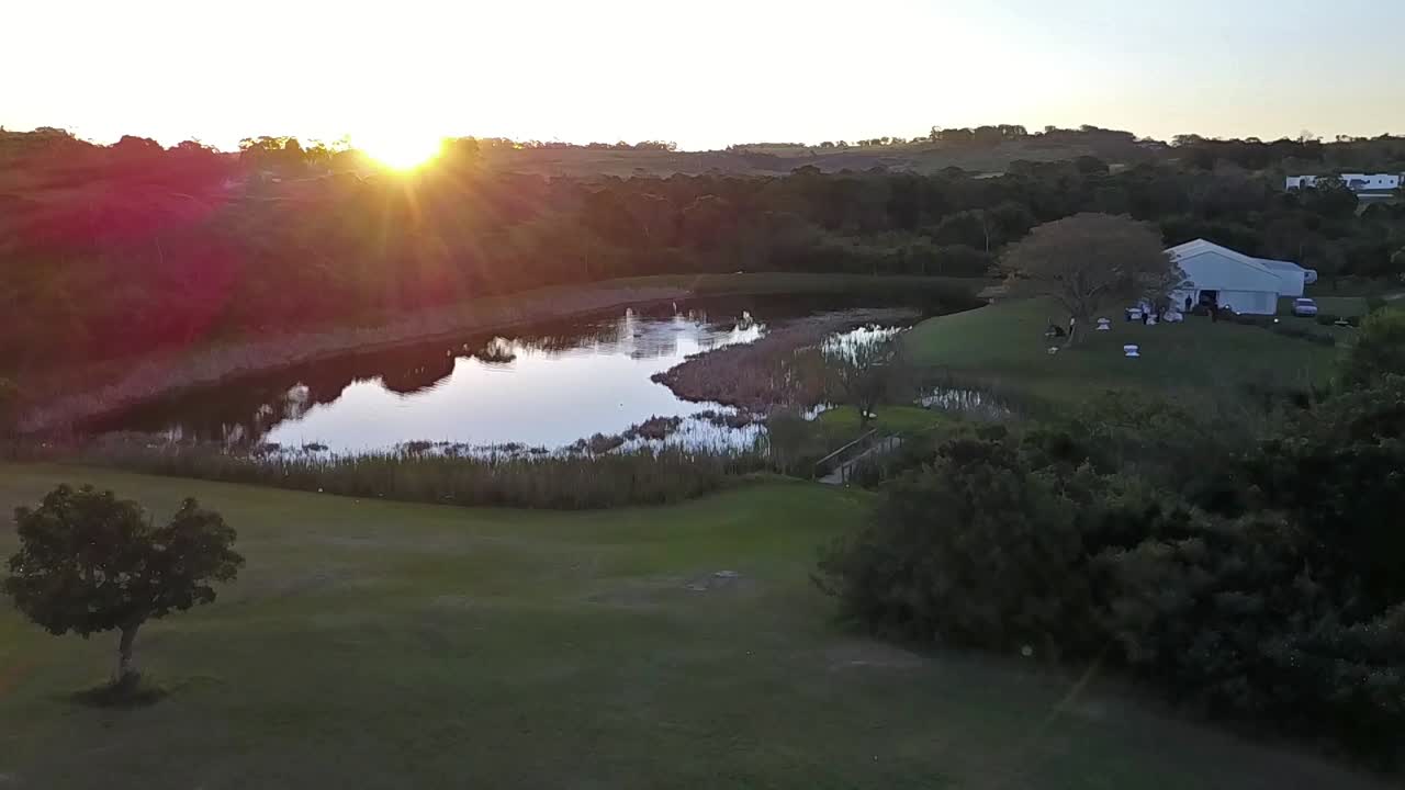 Flying over a dam and wedding tent at sunset