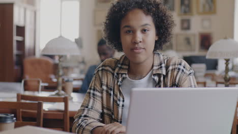 una mujer joven estudiando en una biblioteca.