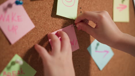 Un-Niño-Pequeño-Fija-Un-Memo-Stick-Con-Palabras-Palomitas-De-Maíz-En-Un-Tablero-De-Corcho.