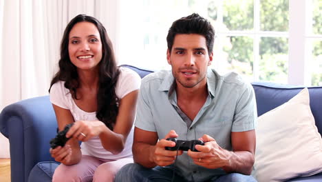 attractive couple playing video games on the couch