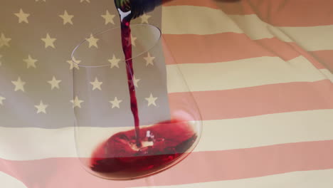 compuesto de vino tinto que se vierte en un vaso sobre la bandera de estados unidos de fondo