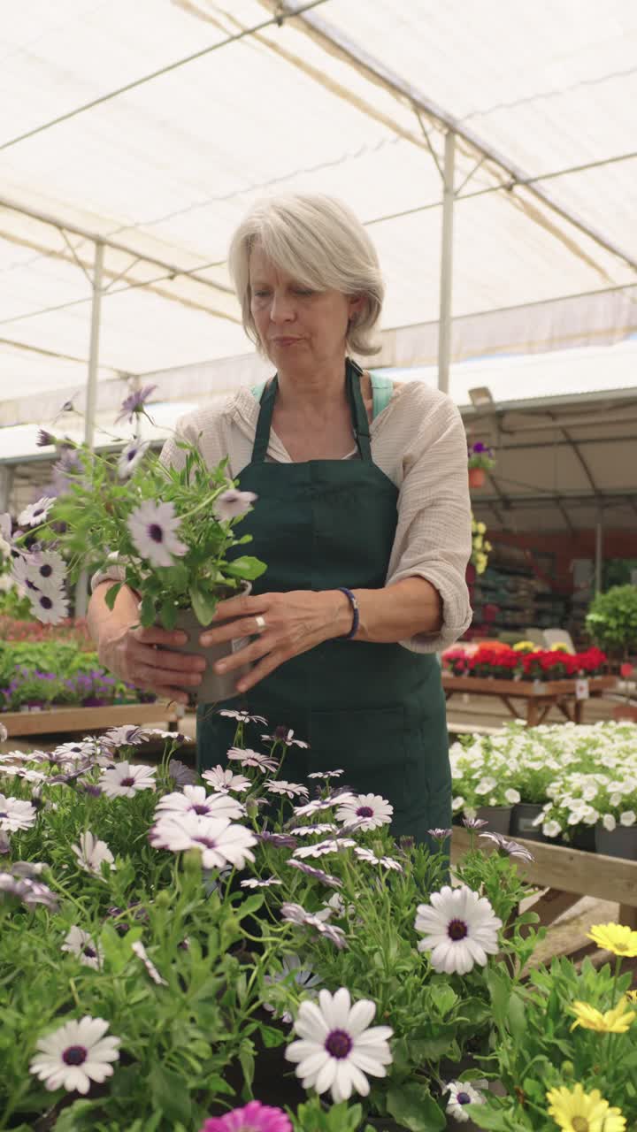 Donna che cura i fiori in una serra