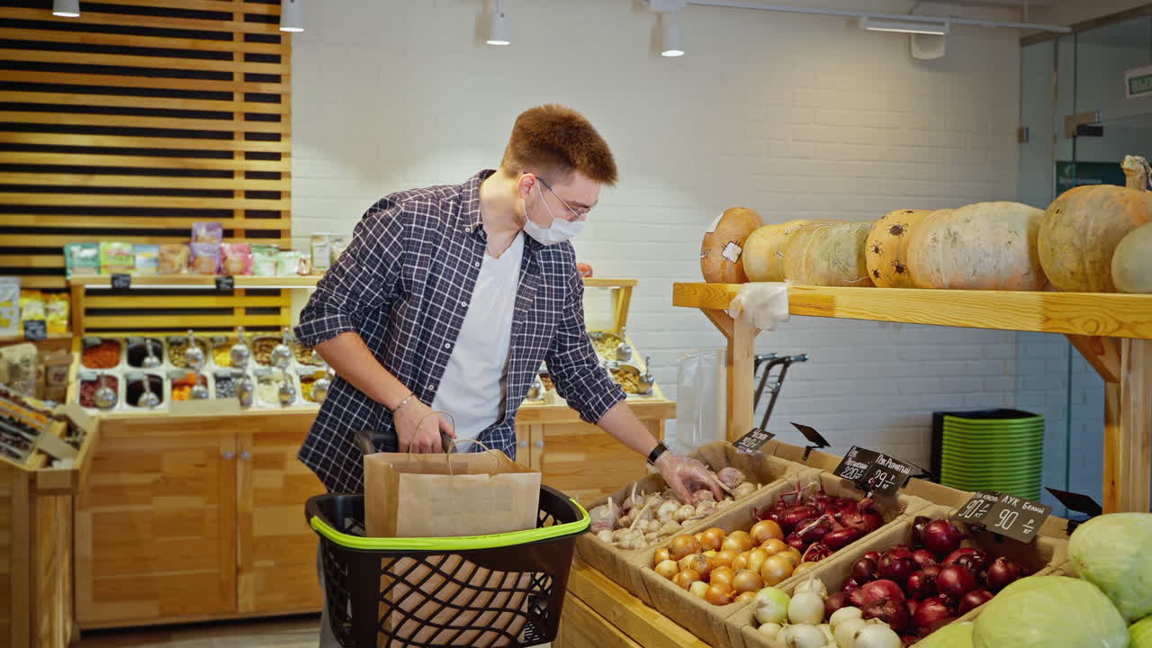 человек, покупающий продукты в продуктовом магазине в маске.