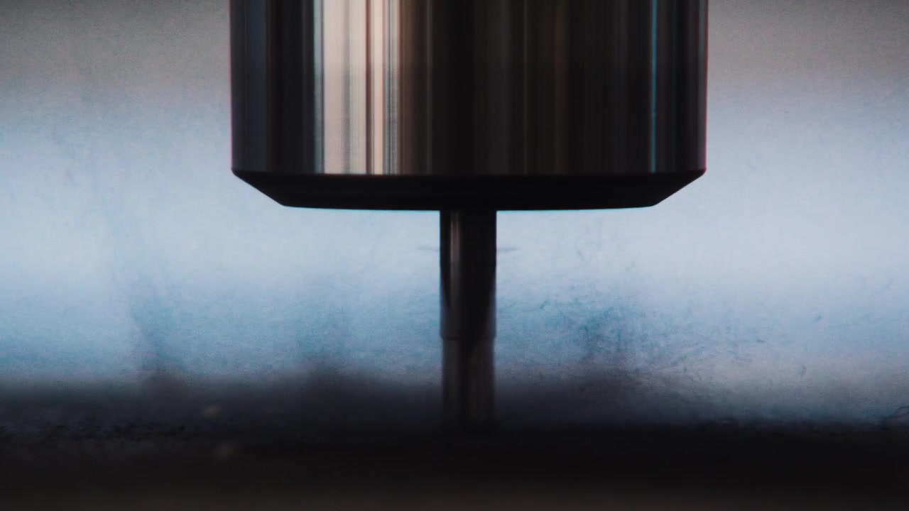 Scatto macro minimale di una fresa a candela verticale che poggia appena sopra una superficie piana di materiale