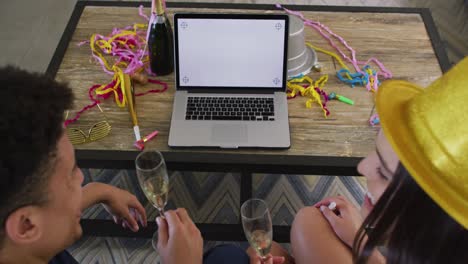 feliz pareja biracial haciendo celebración llamada de video portátil con espacio de copia en la pantalla