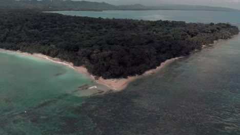 the beautiful green lush island of costa rica surrounded by turquoise blue water - aerial shot