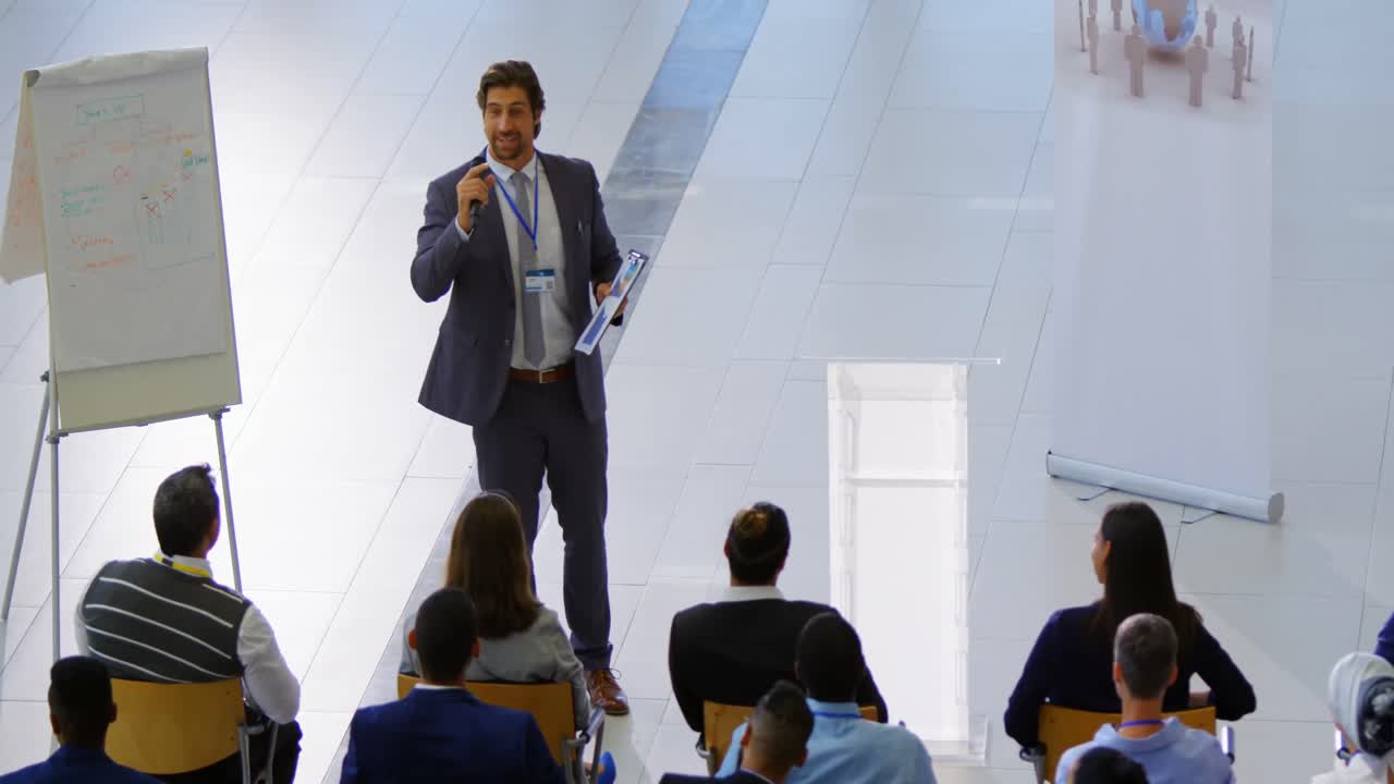 orador masculino con clipboard hablando en el seminario de negocios 4k