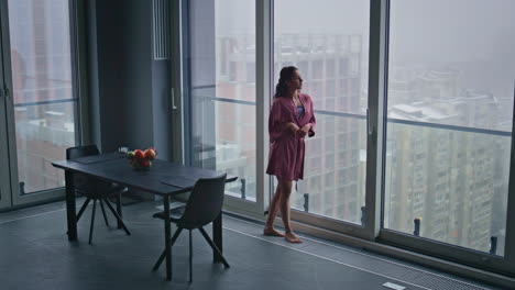 domestic lady looking panoramic window thinking future in contemporary kitchen