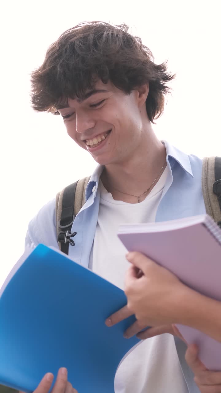 Student laughing while reading notes on white background
