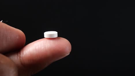 a white pill on a finger