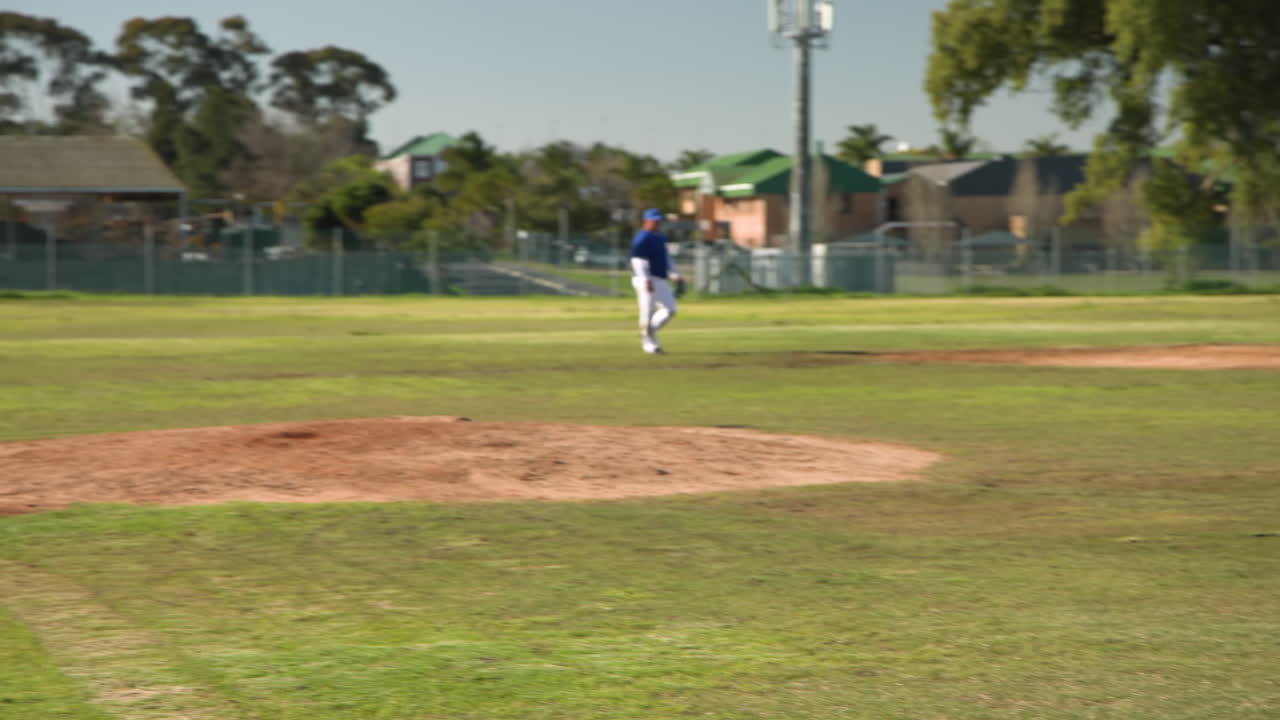 Playing baseball, pitcher throwing ball to batter on field during game