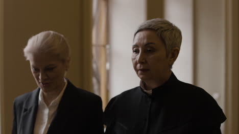 two women in formal attire in a courtroom