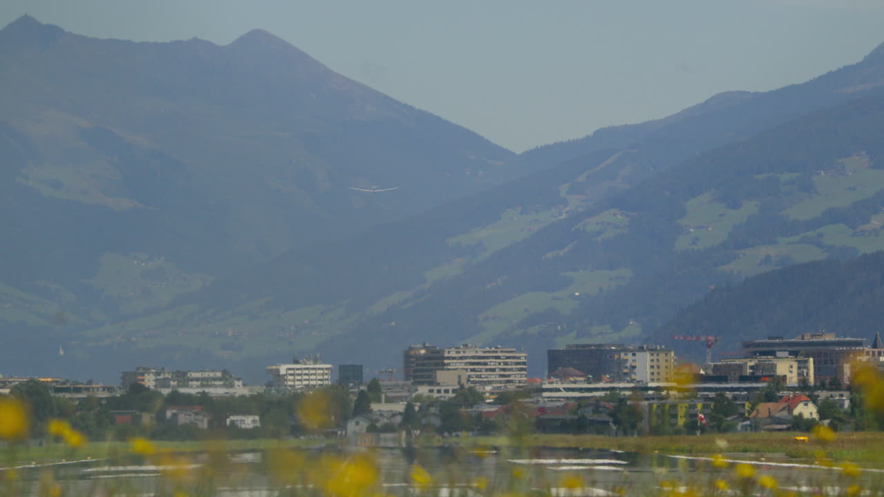 산의 도시 위를 날아다니는 글라이더