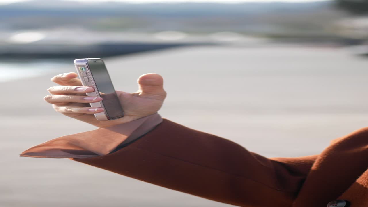 야외에서 스마트폰을 사용하는 여성