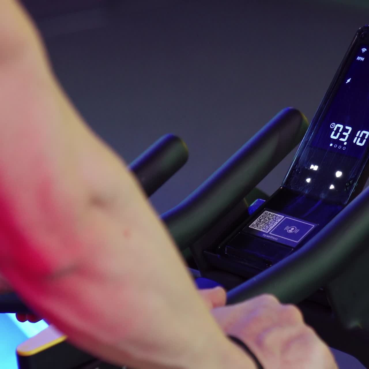 Cardio training on stationary bike. Close up of man exercising legs doing cardio workout cycling bikes