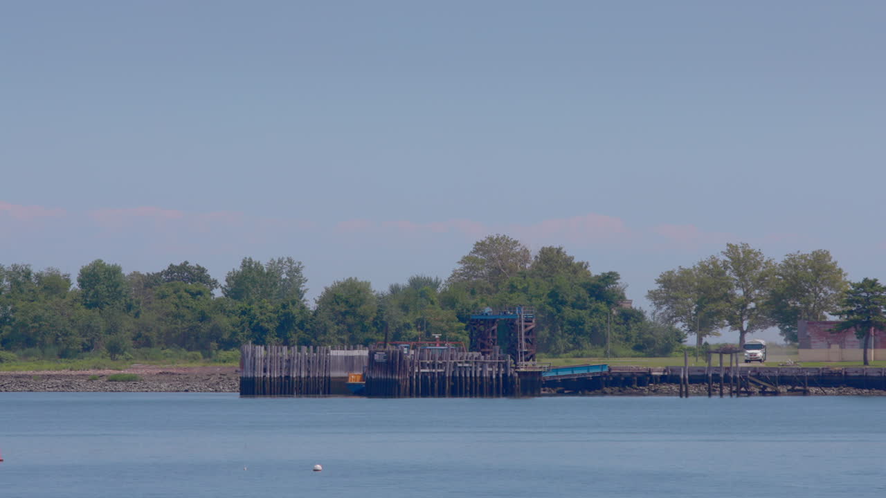 백색 교도소 버스가 뉴욕의 하트 아일랜드에 도크에 들어갑니다.