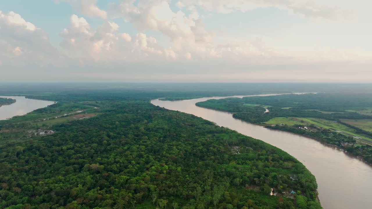 Drone view of San José del Guaviare, Colombia, highlighting dense tropical forest, river movement, and a crossing route through the Amazon environment