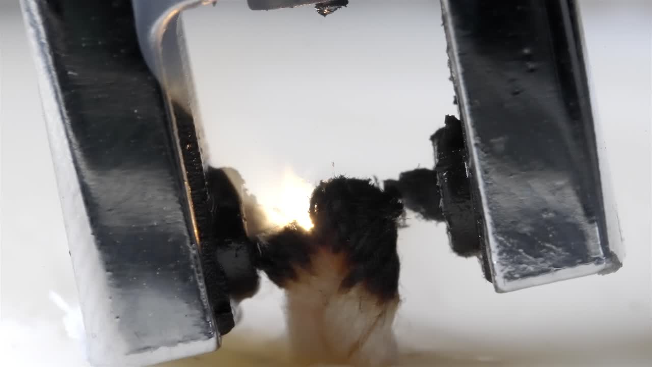 A detailed close-up of an arc lighter igniting a candle, creating a soft glow.