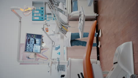 vertical video: woman dentist preparing stomatology chair