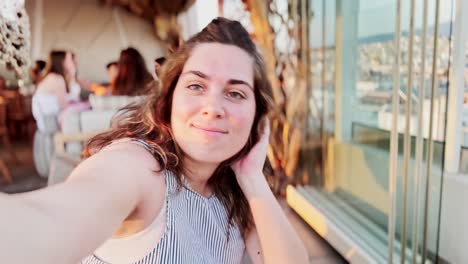 smiling woman taking selfies outdoors during golden hour