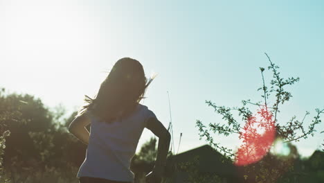 girl running in a field at sunset