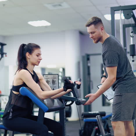 beautiful athletic young woman making exercise at the gym. exercises for biceps. personal training.