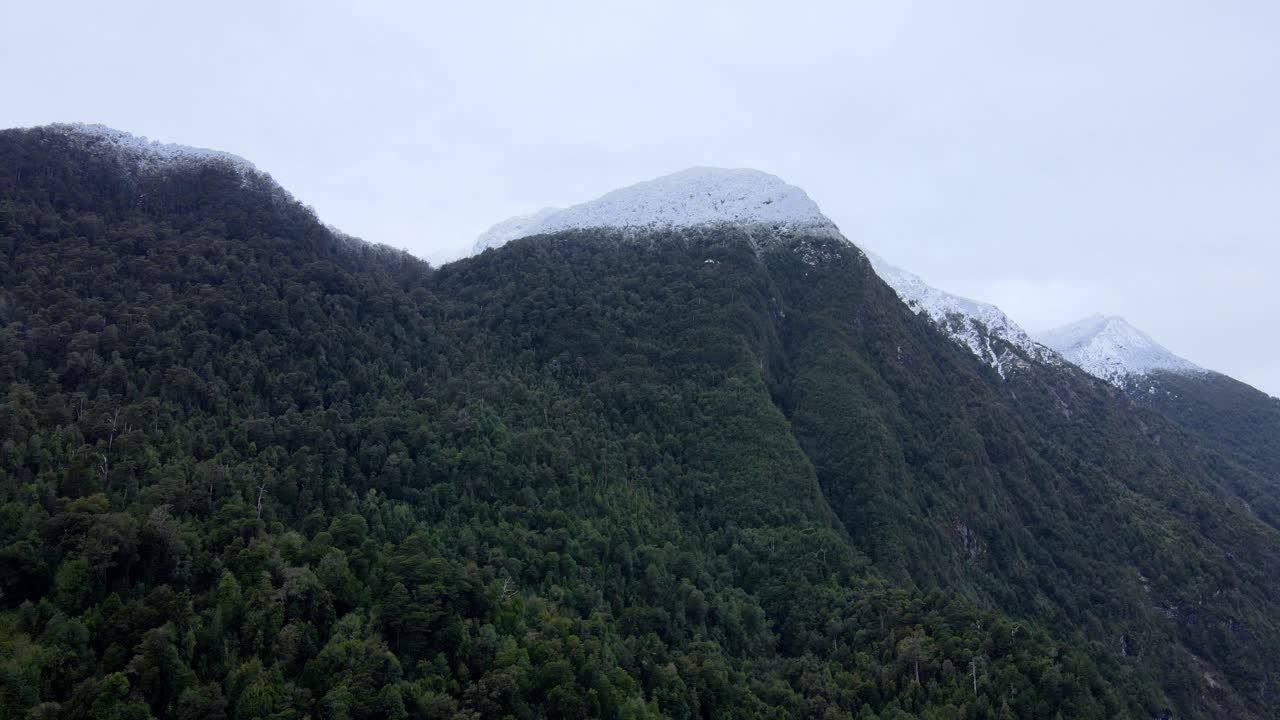 órbita aérea y montañas cubiertas de nieve, lago tagua tagua, sur de chile