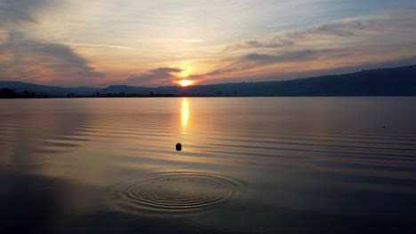 sun rise mirroring in the lake passing the diving platform on the right