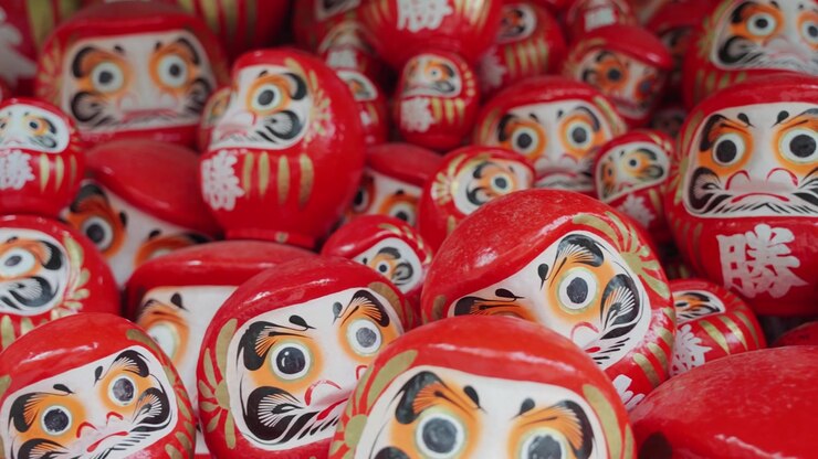 Numerose bambole Daruma rosse esposte al Tempio Katsuoji a Osaka, Giappone, che mostrano un simbolo tradizionale giapponese associato a buona fortuna, perseveranza, desideri e successo