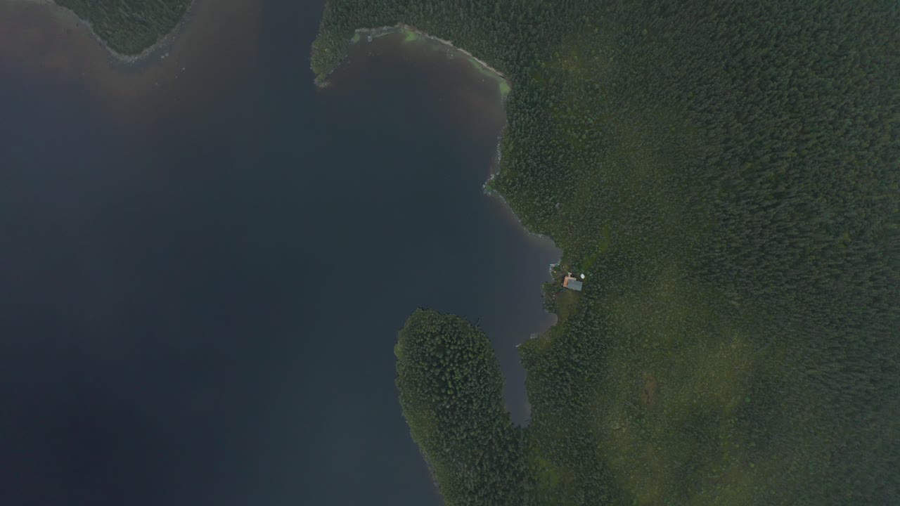 호수 위의 숲 속 고립된 오두막을 내려다보는 구름의 공중 전망