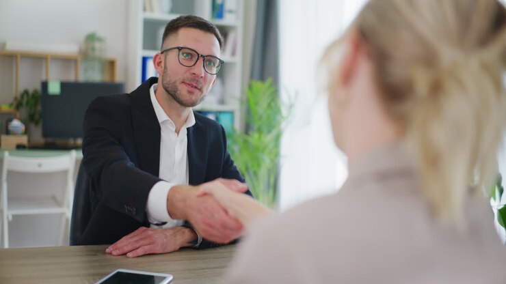 Smiling Real Estate Agent Shakes Hands During Negotiations